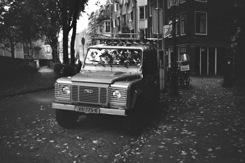 a black and white photo of a truck parked on a street