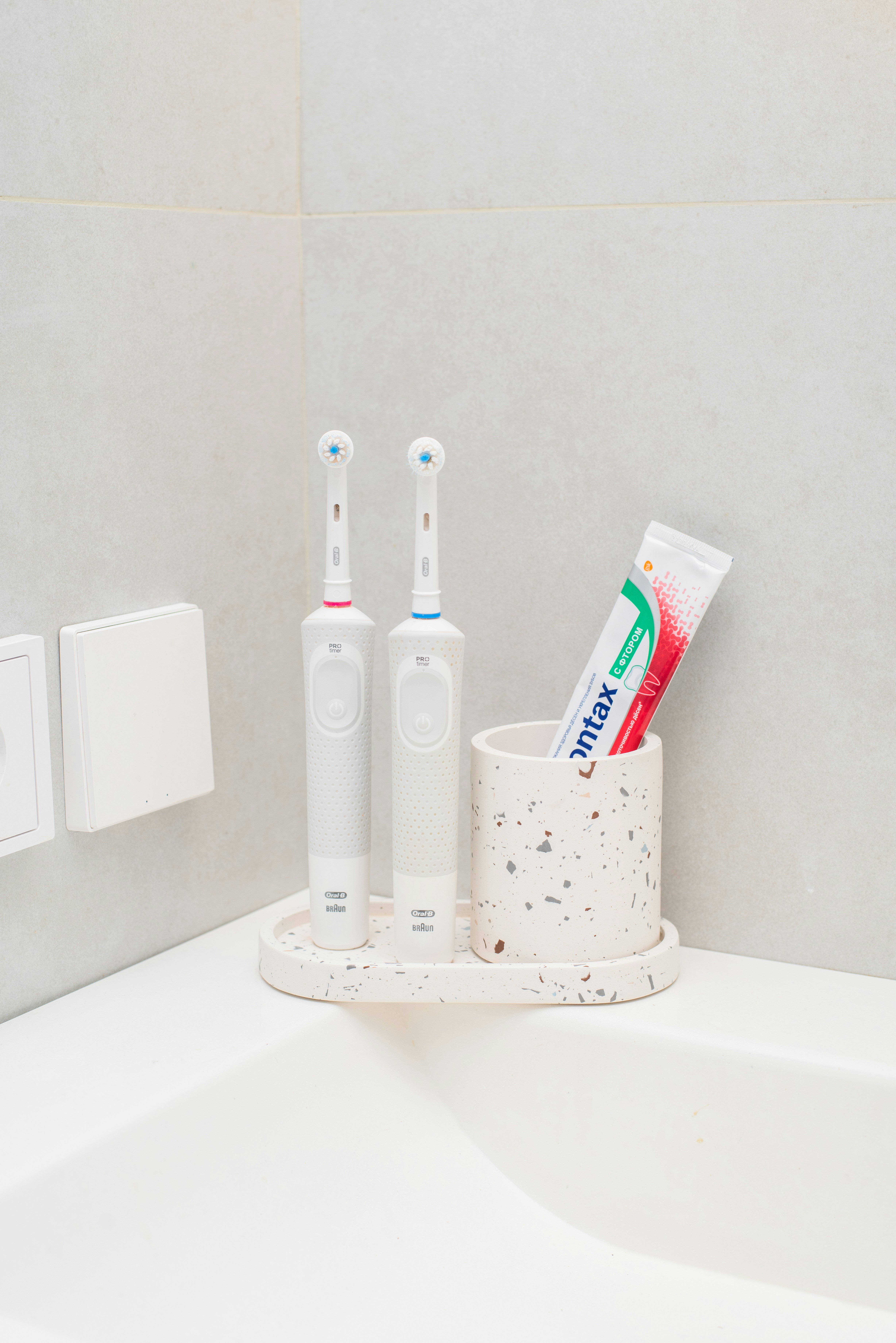 a toothbrush, toothpaste, and toothpaste holder in a bathroom