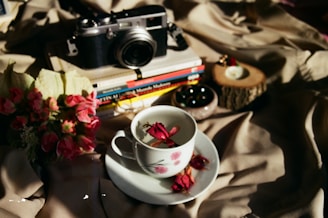 A cozy corner with pink cushions and a camera resting on a white table, symbolizing memories.