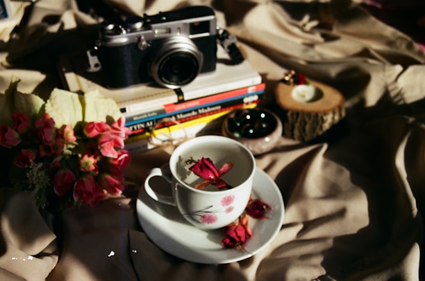 A cozy corner with pink cushions and a camera resting on a white table, symbolizing memories.
