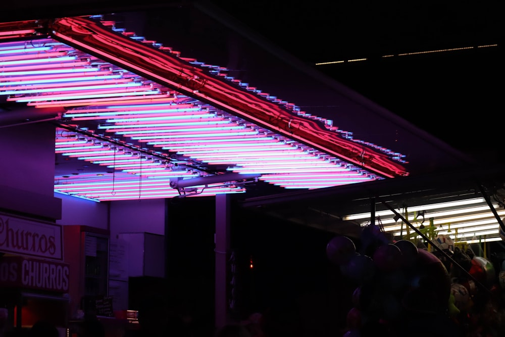 a group of people standing under a neon sign