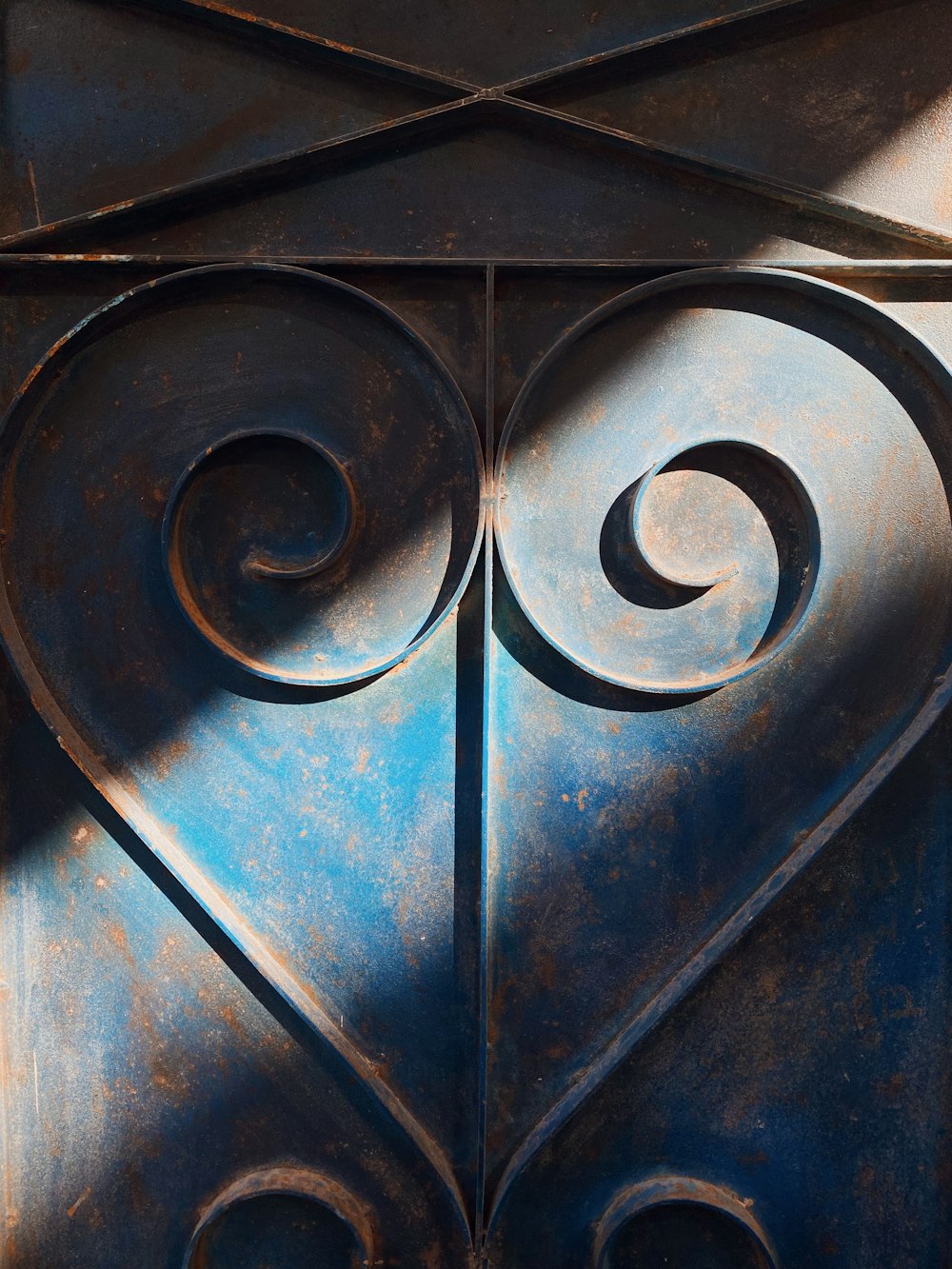 a close up of a metal door with a spiral design
