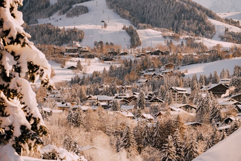 a snow covered mountain with a village in the distance