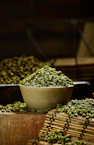 a bowl filled with green peas sitting on top of a wooden table
