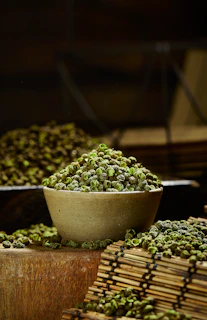 a bowl filled with green peas sitting on top of a wooden table