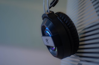 Close-up of modern wireless headphones with neon blue accents on a black background.