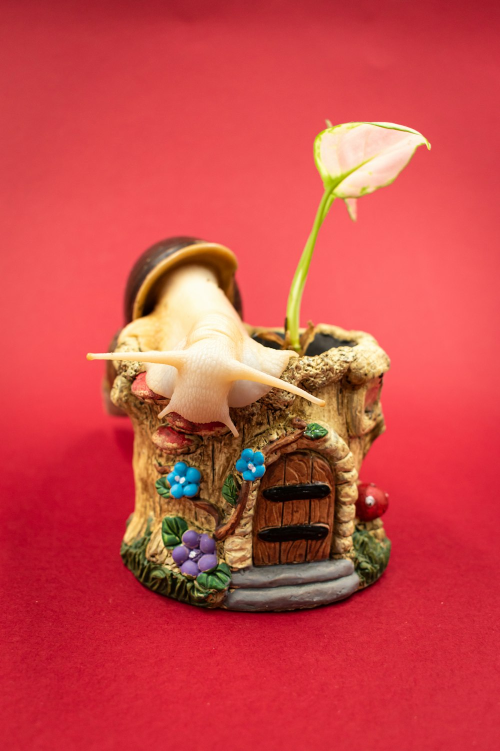 une petite figurine d’une maison champignon avec une fleur qui en sort