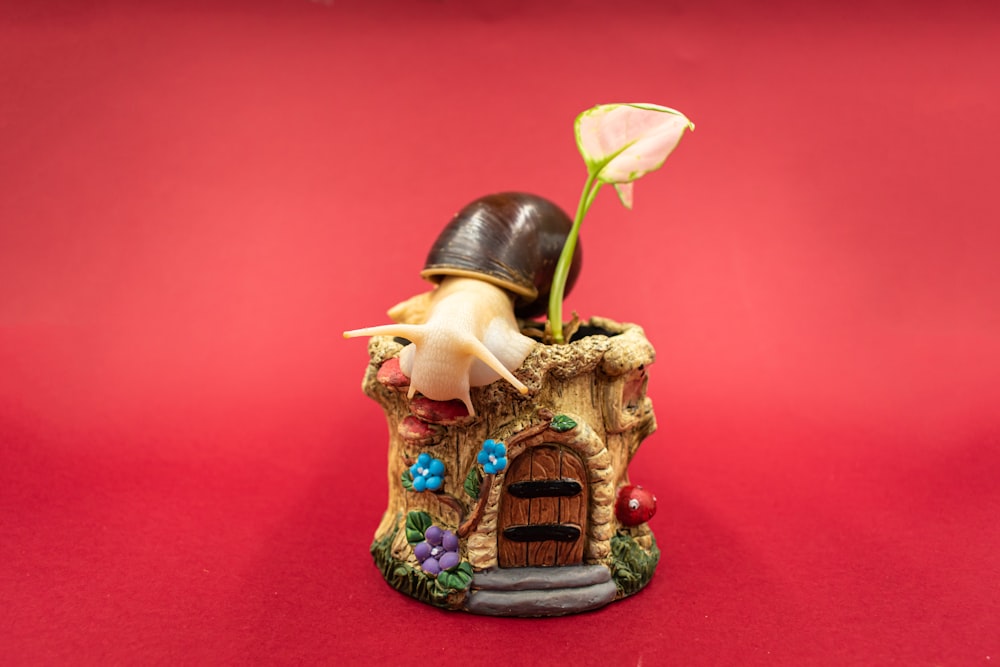 Une figurine d’un gnome avec un chapeau et une fleur