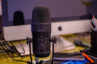 A microphone surrounded by sheet music and creative studio equipment.