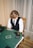 a young boy sitting at a green table with cards