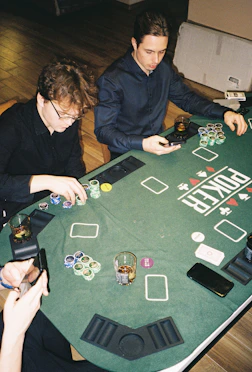 two men sitting at a table playing a game of poker