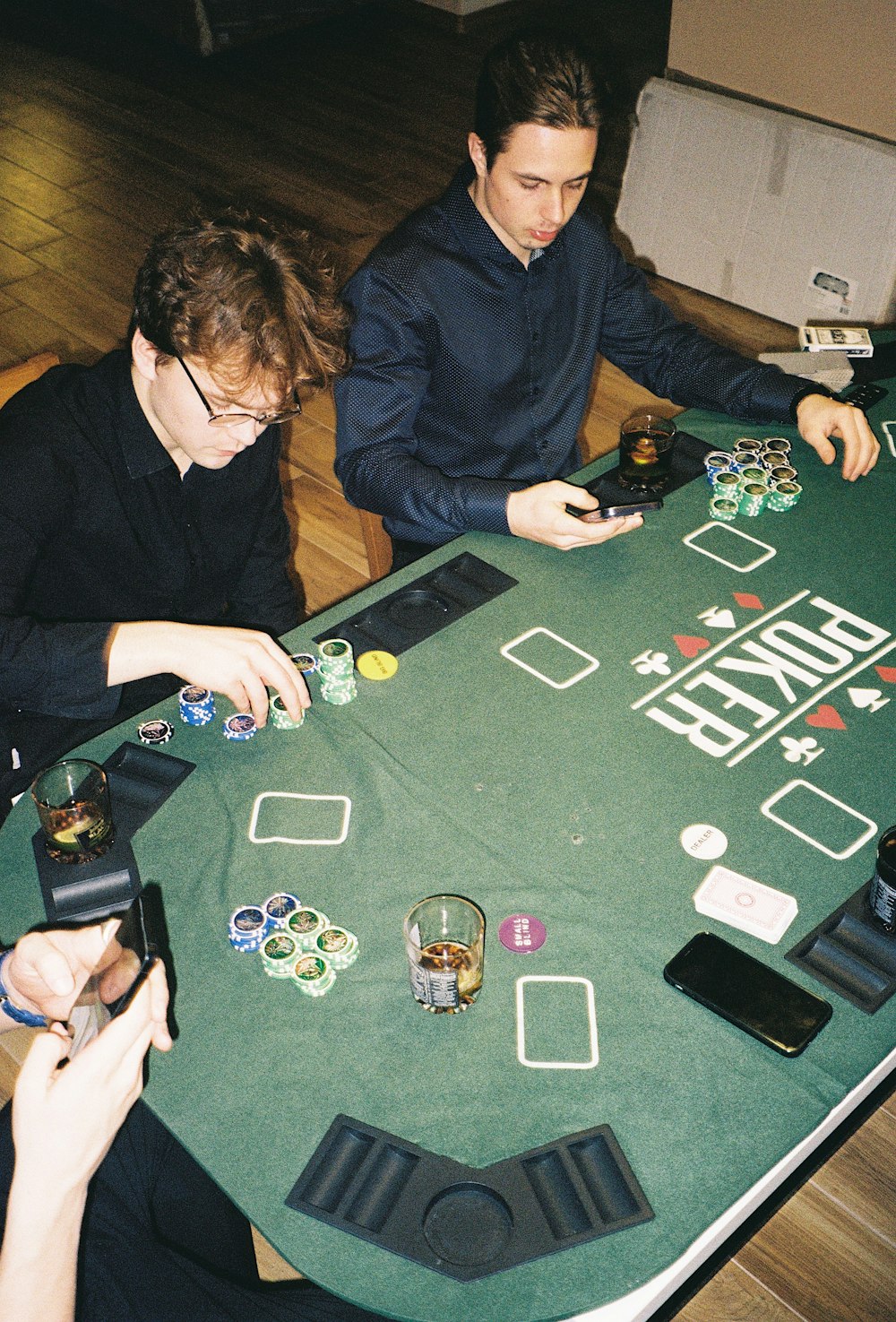 Dos hombres sentados en una mesa jugando una partida de póquer