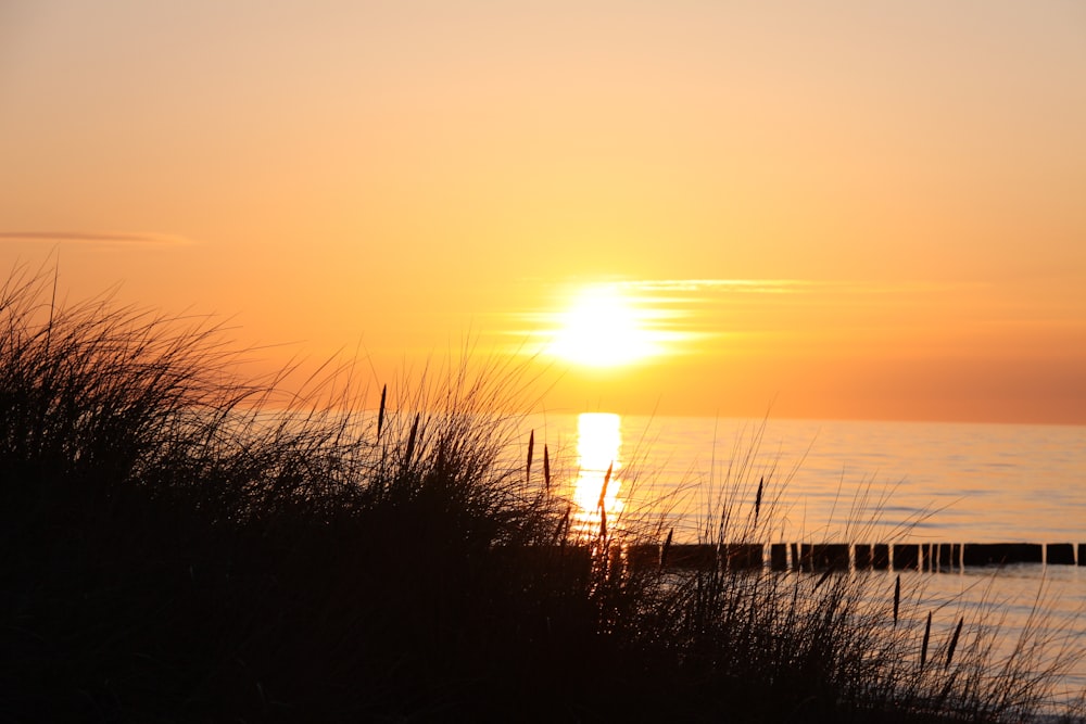 the sun is setting over a body of water