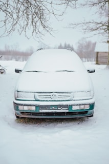 a car covered in snow parked in the snow
