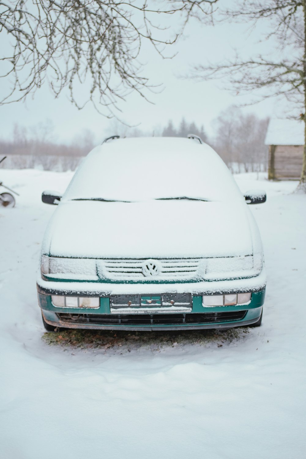 a car covered in snow parked in the snow