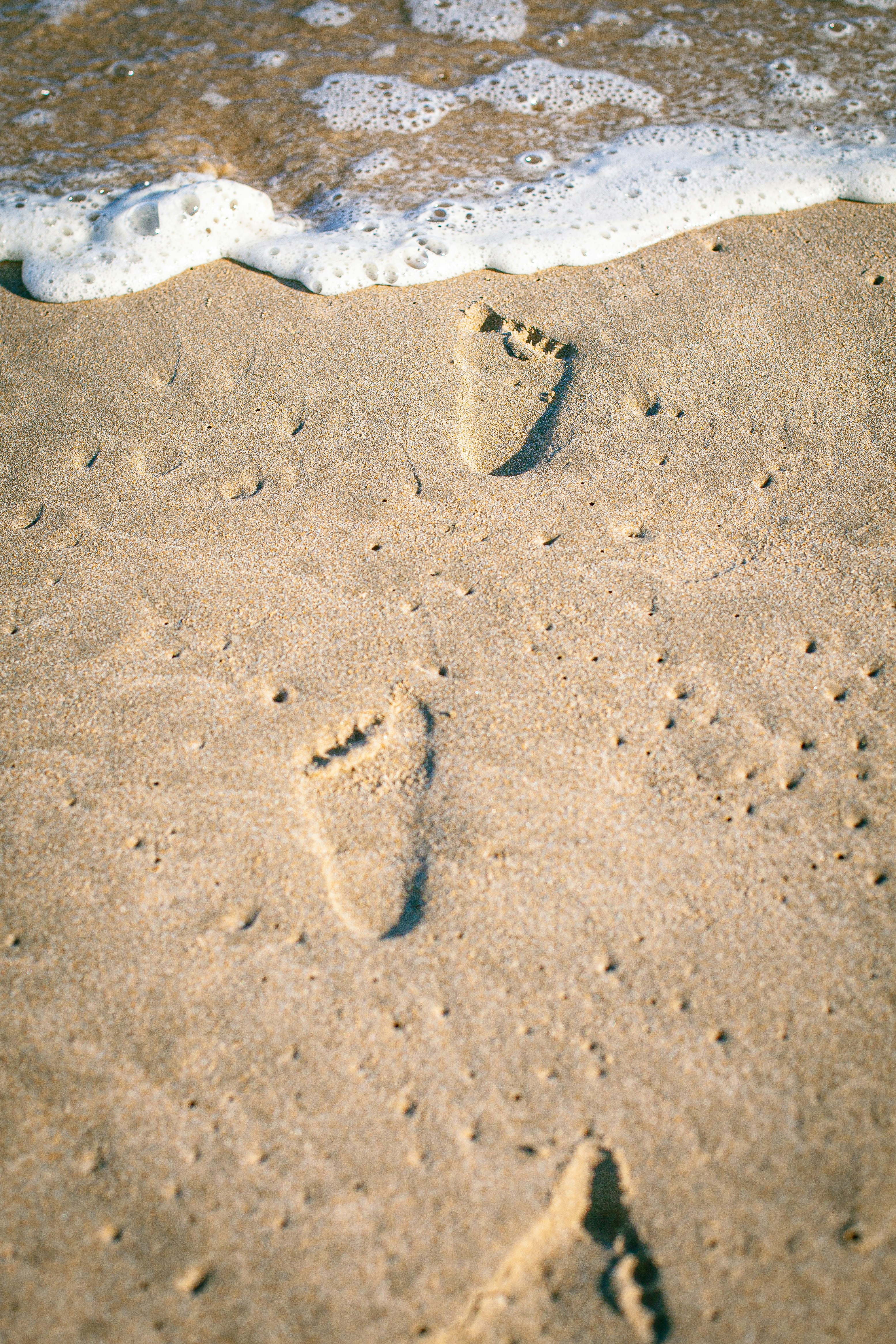 a person's footprints in the sand at the beach