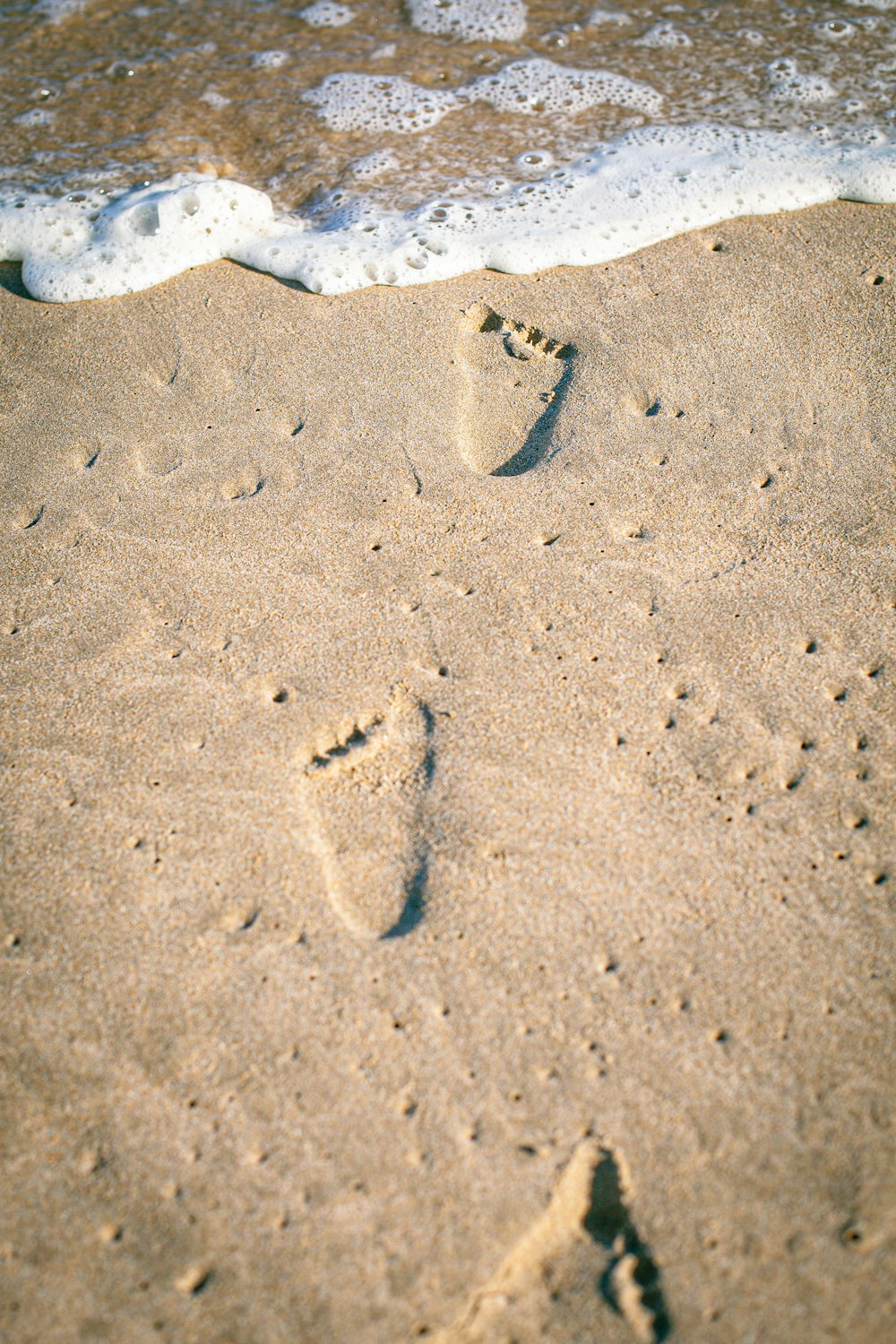 a person's footprints in the sand at the beach