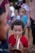A joyful child playing a musical instrument at a community music event.