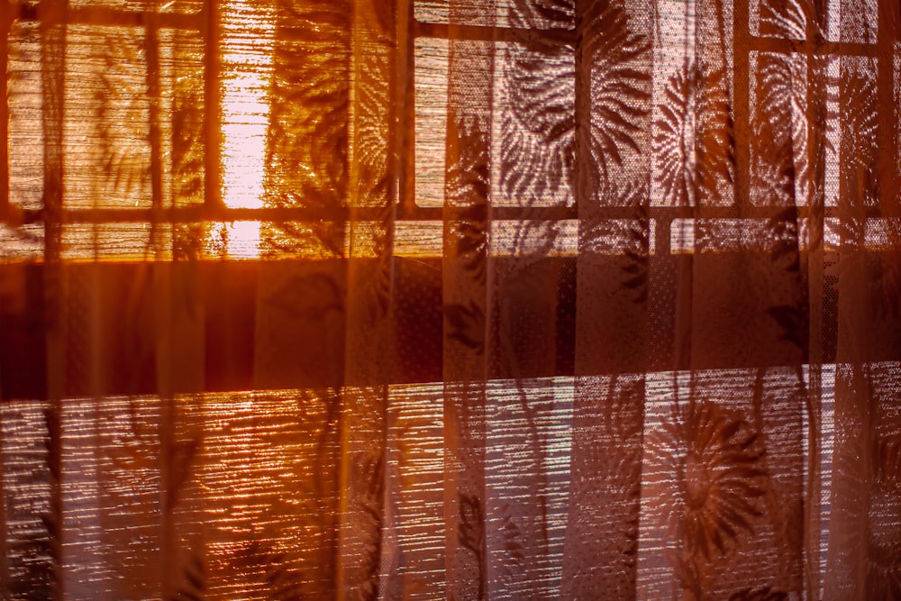 a close up of a sheer curtain with leaves on it