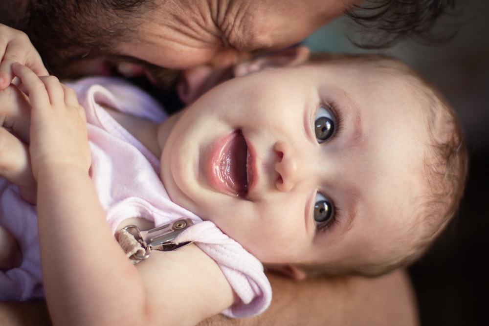 a close up of a person holding a baby