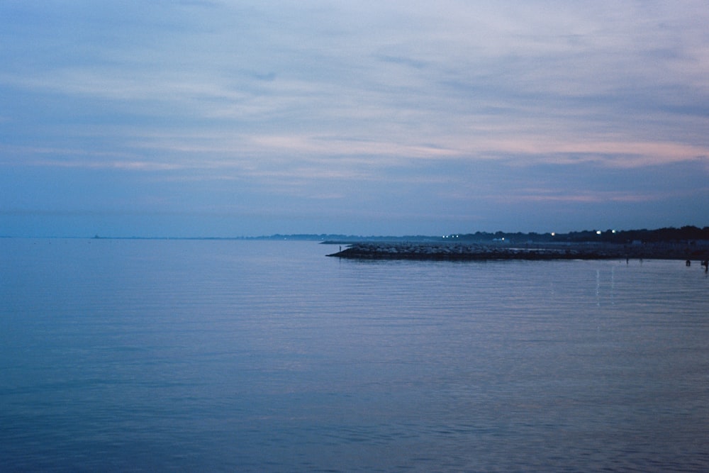 a body of water with a sky in the background