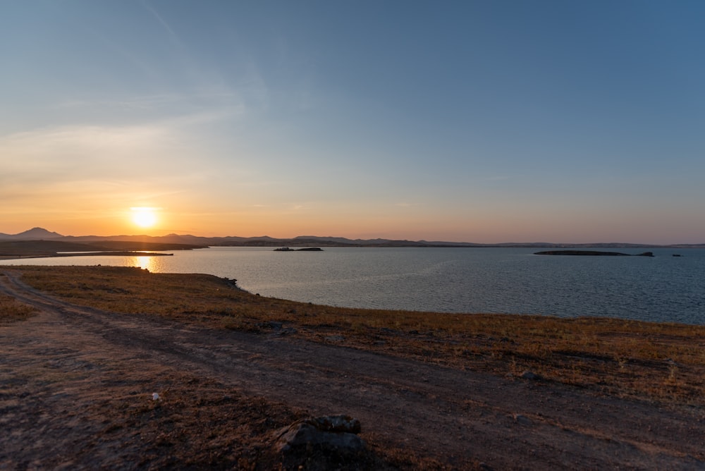 the sun is setting over a body of water