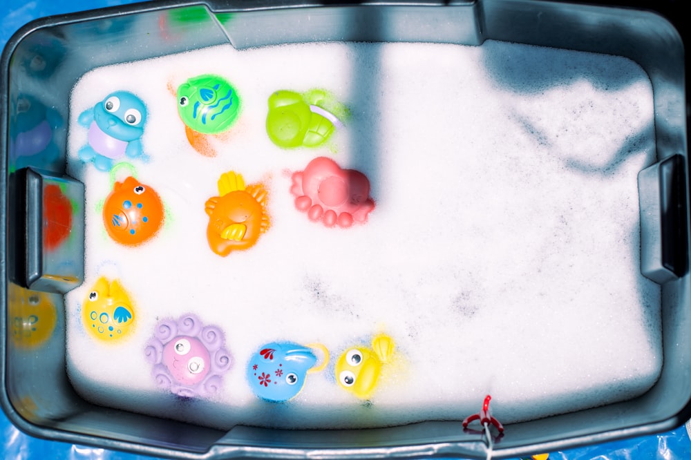 a bath tub filled with lots of different colored toys