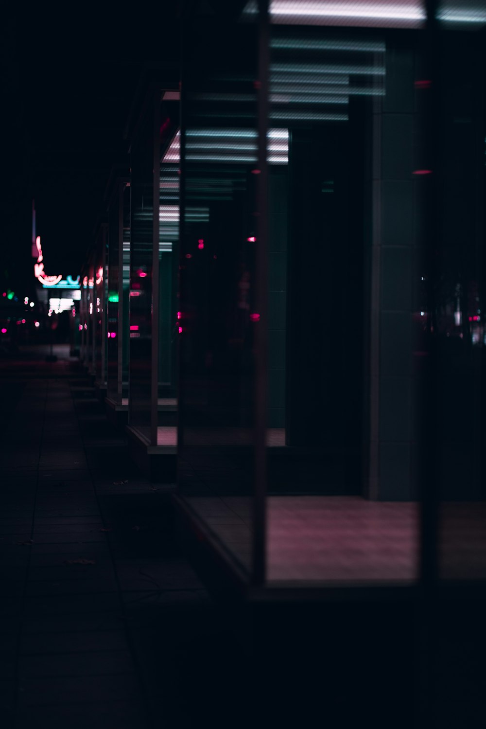 a dark city street at night with a clock tower in the distance