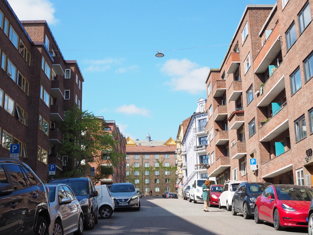 a street lined with parked cars next to tall buildings