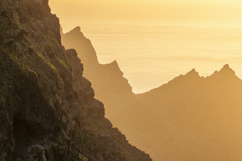 a person on a surfboard is standing on the edge of a cliff