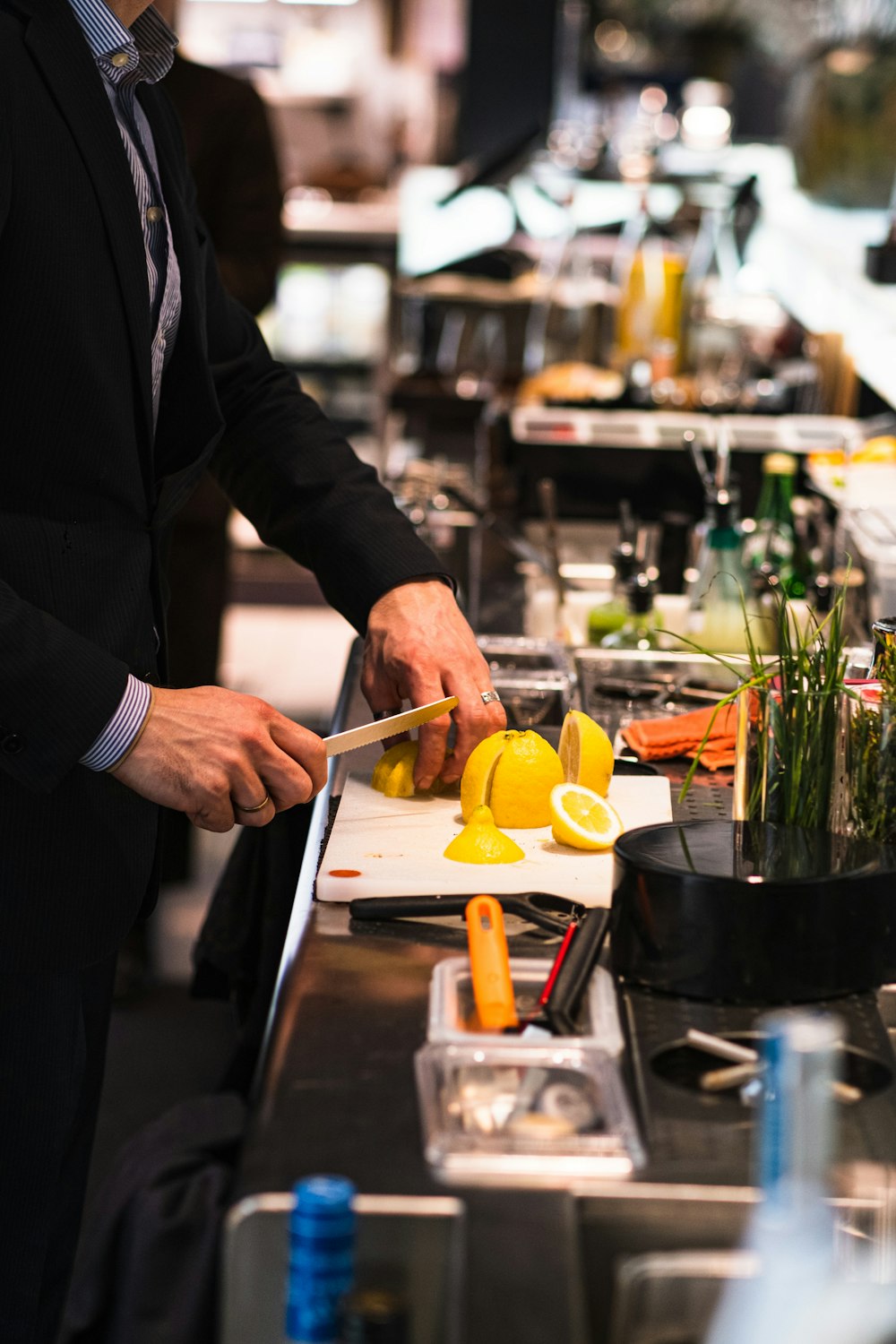 a man in a suit cutting up lemons on a cutting board