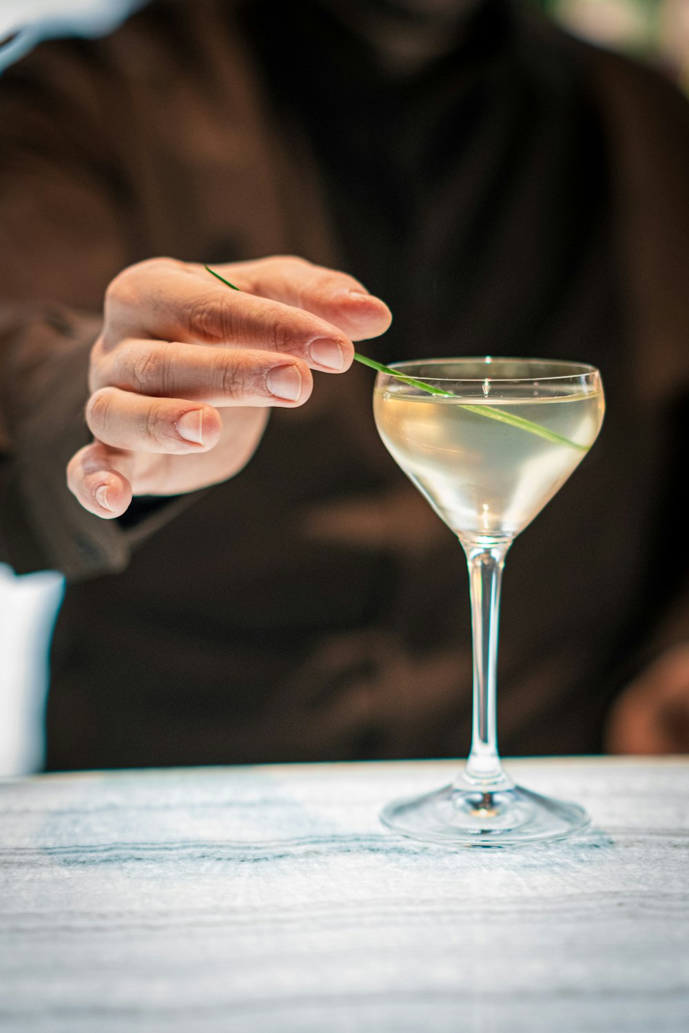 a person holding a flower in a martini glass