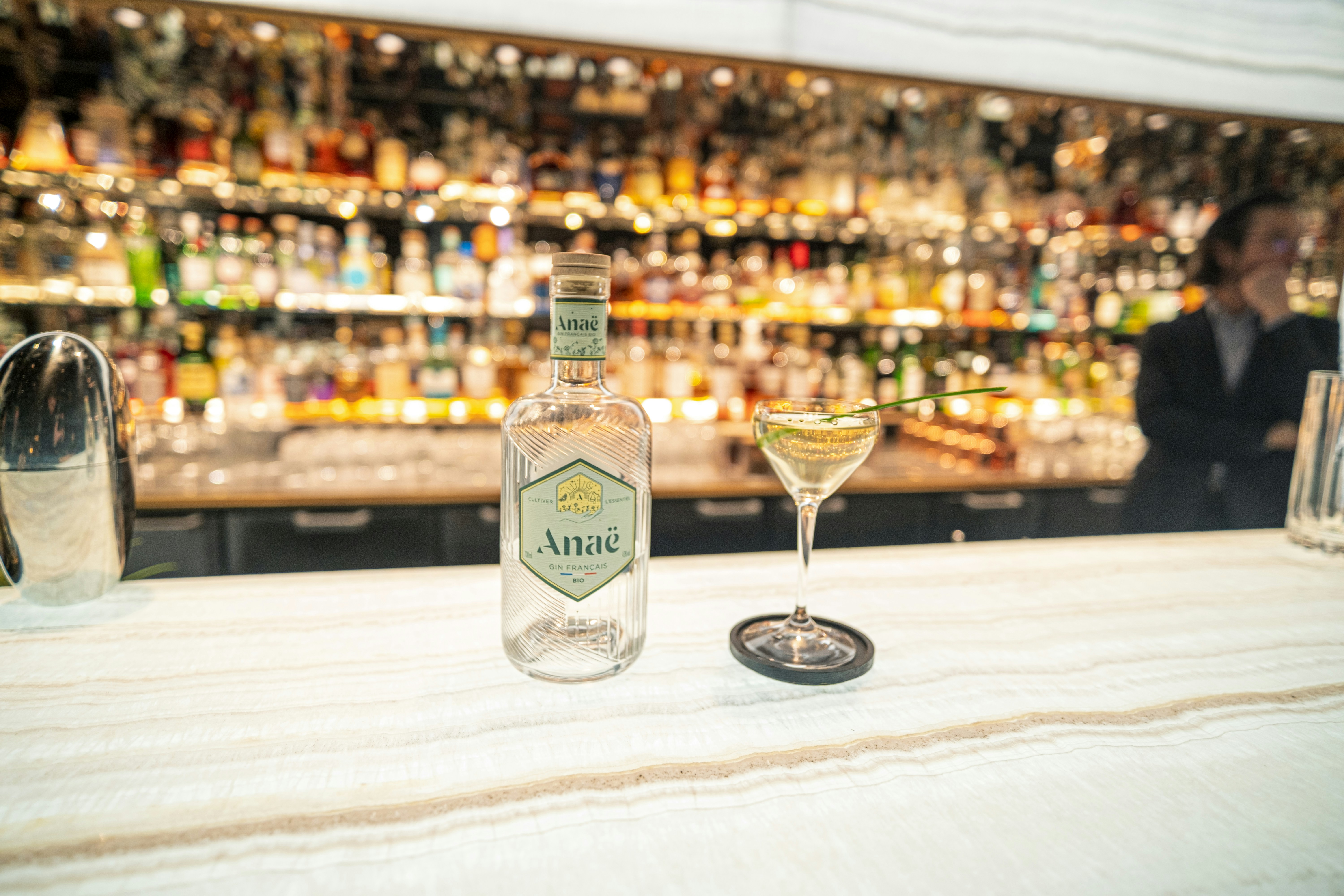 a bottle of alcohol and a glass on a bar, 