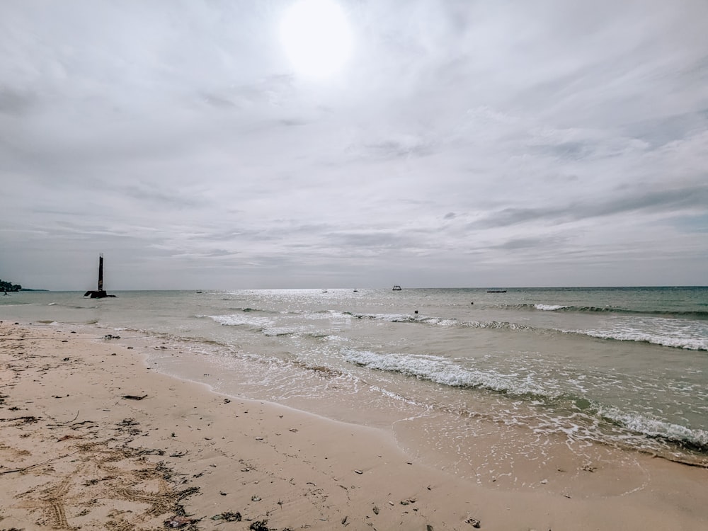 a sandy beach with waves coming in to shore