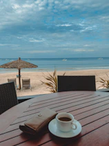 a cup of coffee sitting on top of a wooden table