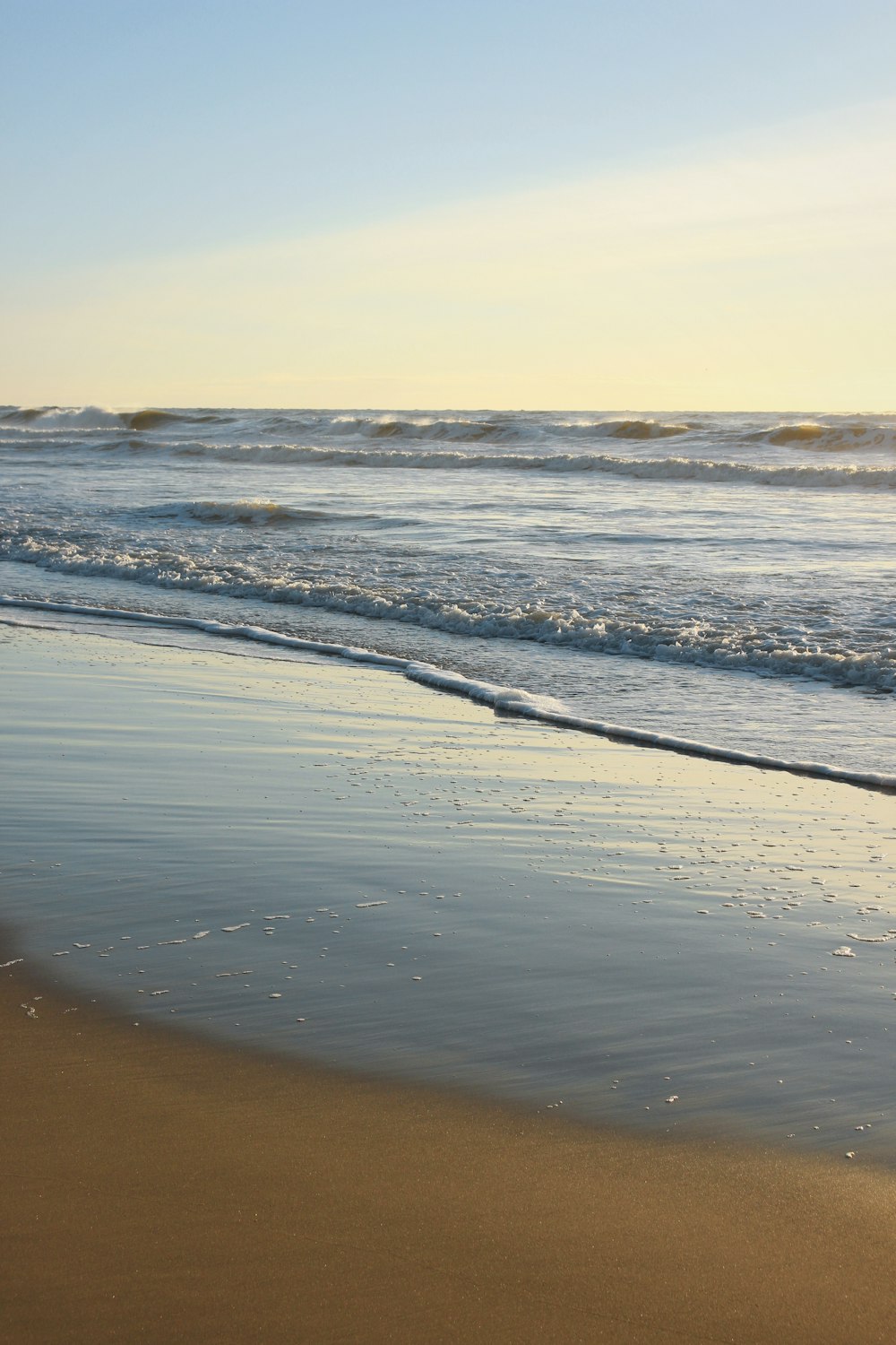 a person walking on the beach with a surfboard