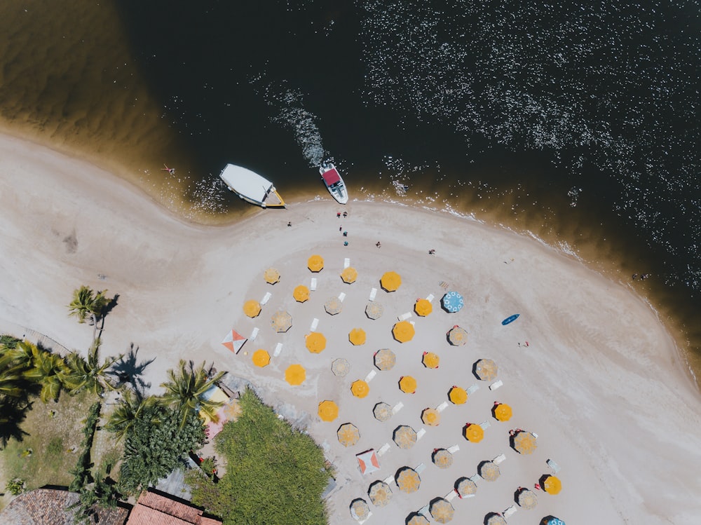 an aerial view of a beach with umbrellas and chairs