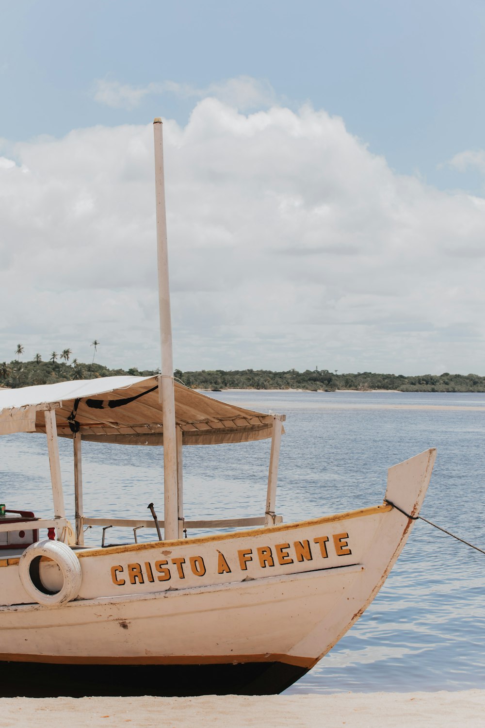 a boat sitting on top of a beach next to a body of water