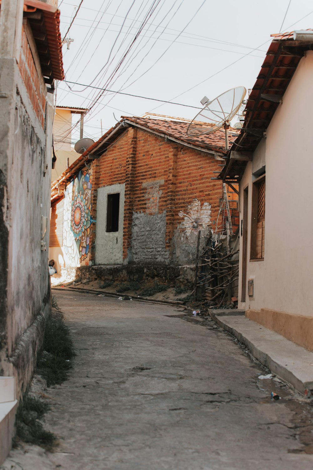 an alley way with a brick building and graffiti on it