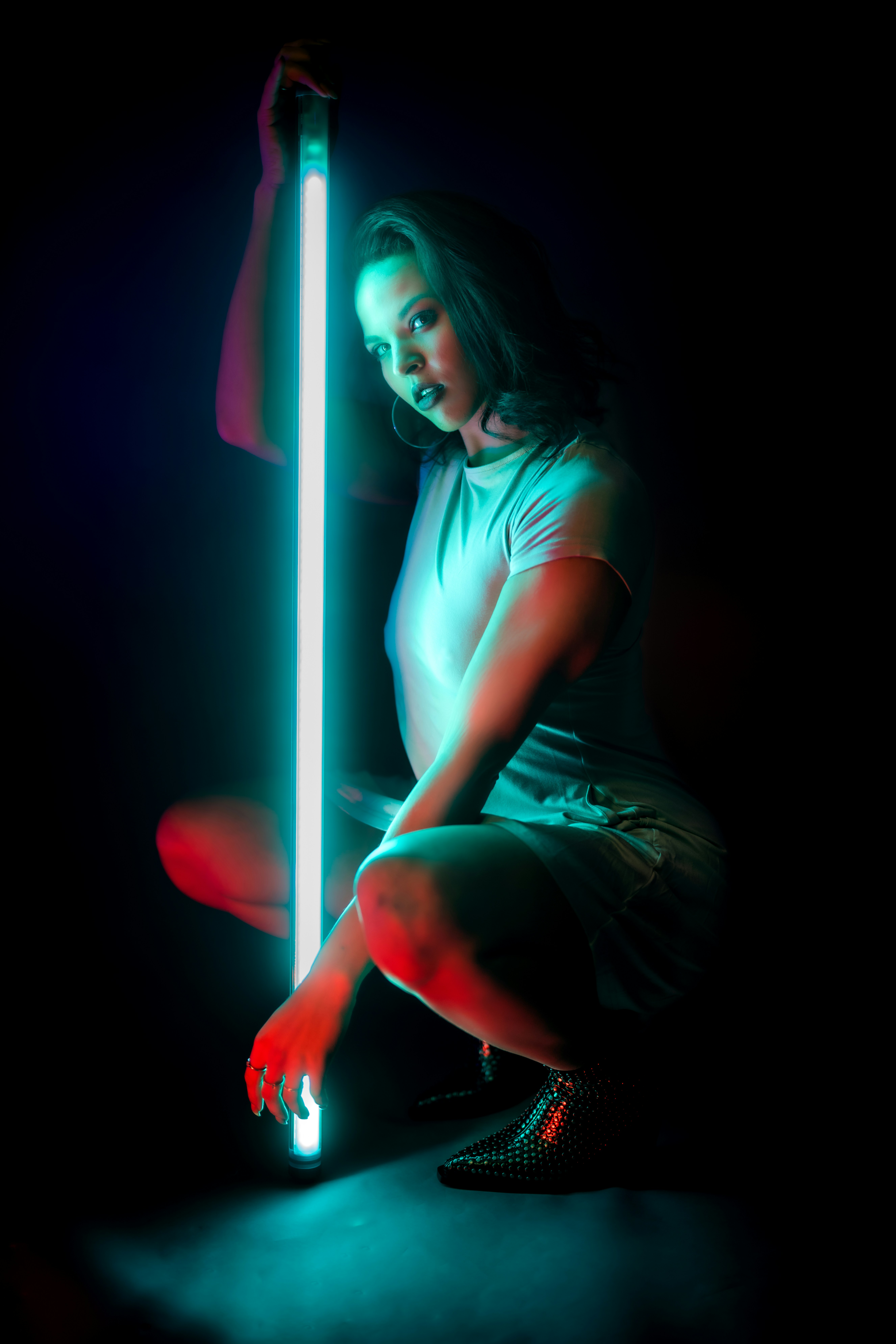 Une femme assise par terre tenant un sabre laser