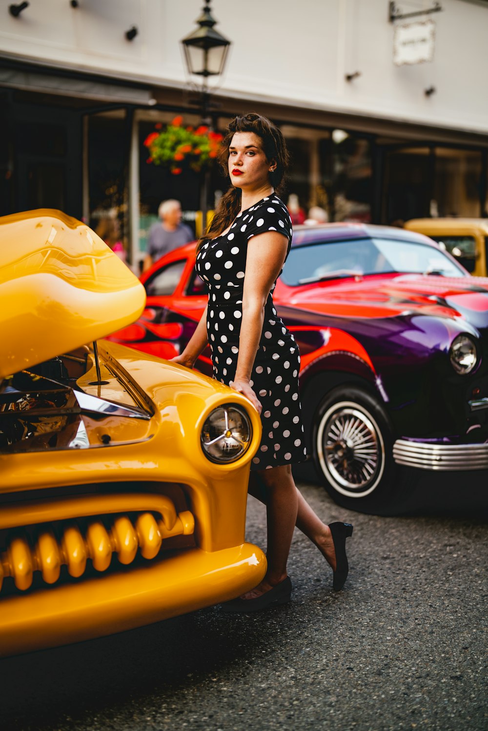 a woman standing next to a yellow car