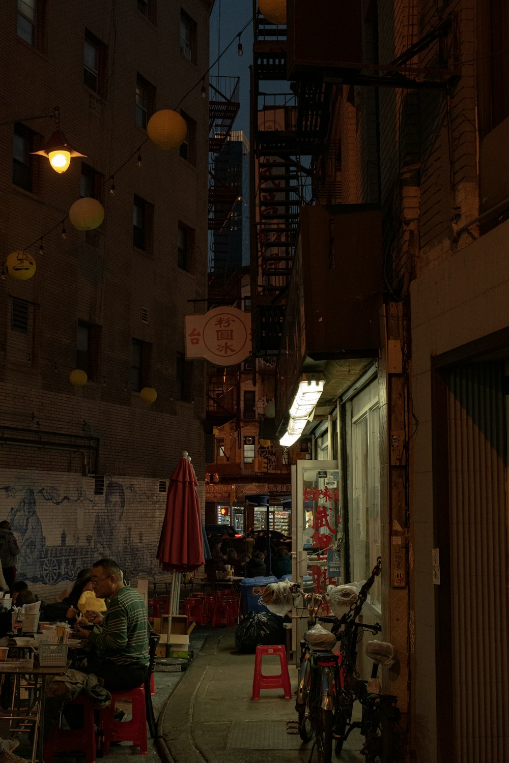 a person sitting at a table in an alleyway