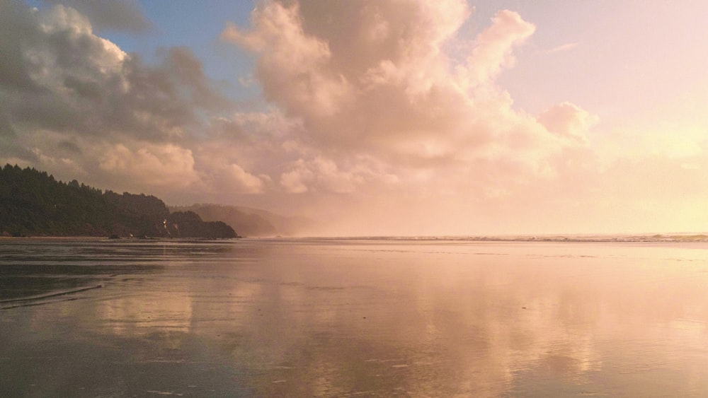 a view of a body of water with clouds in the sky