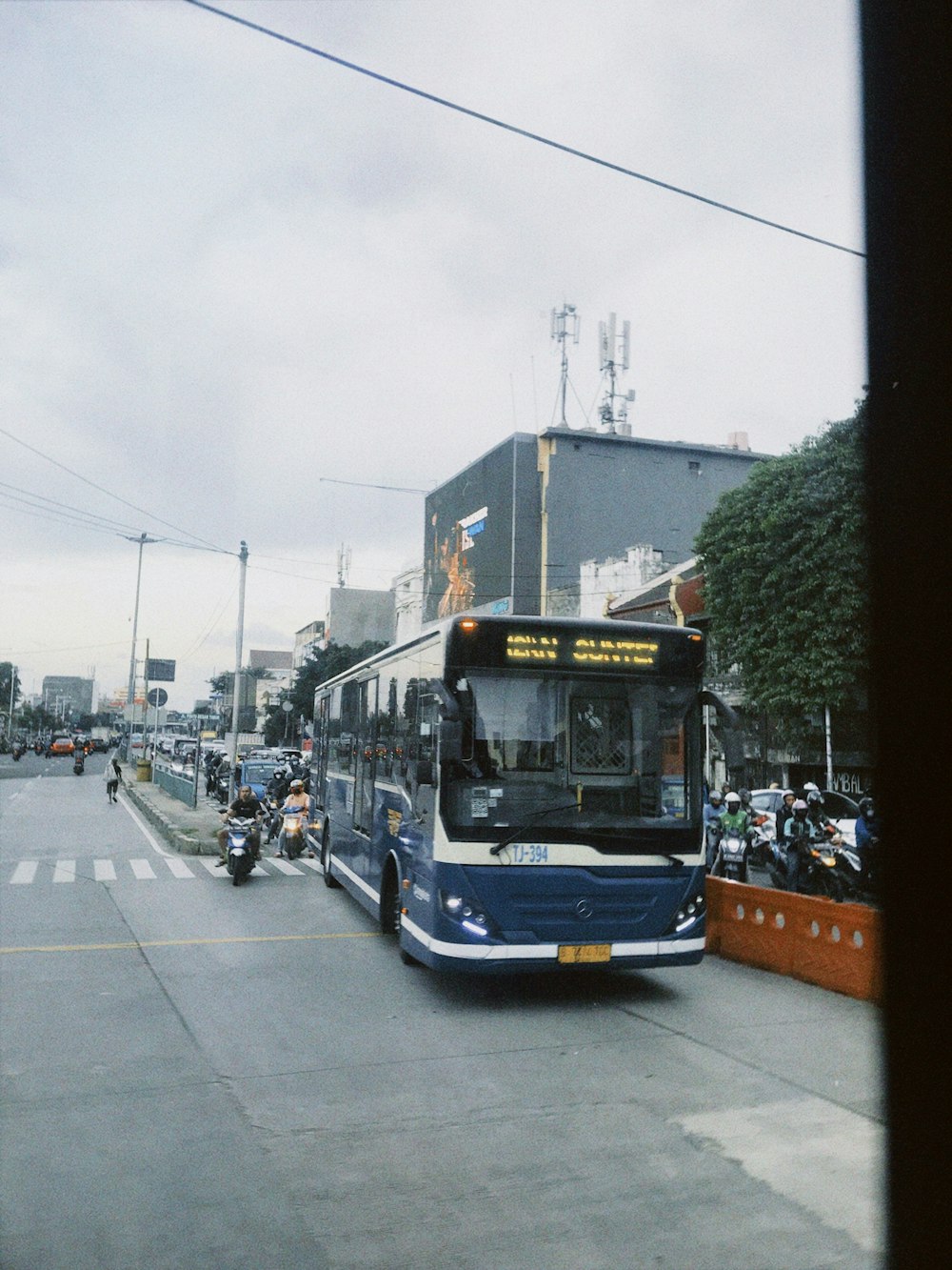 a blue and white bus driving down a street