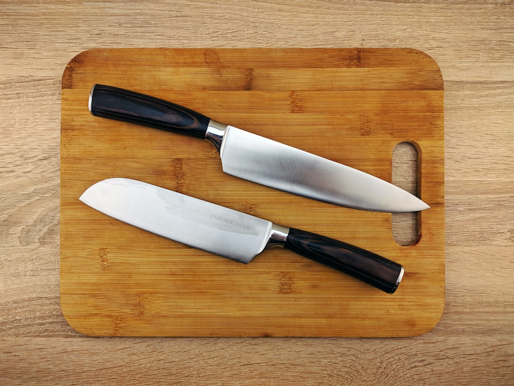 a couple of knives sitting on top of a cutting board