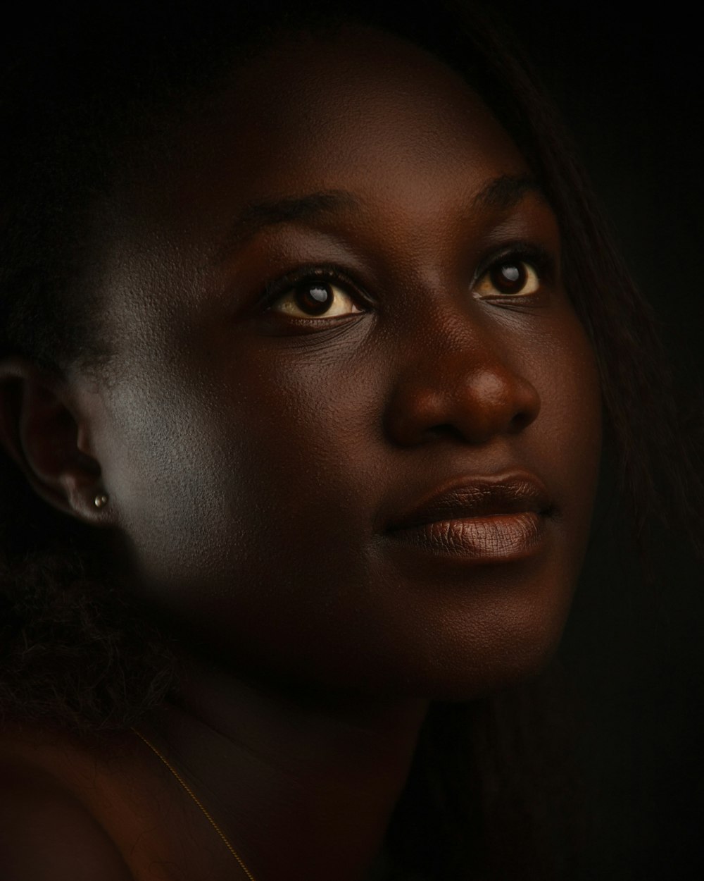 a close up of a woman's face with a dark background