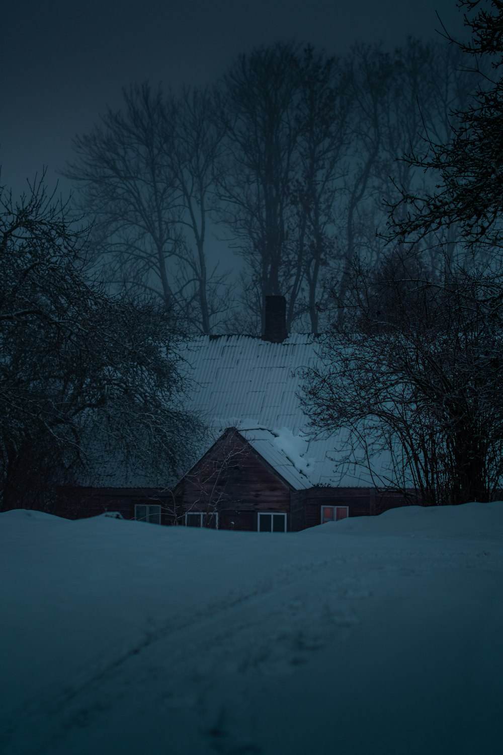 a house in the middle of a snowy field