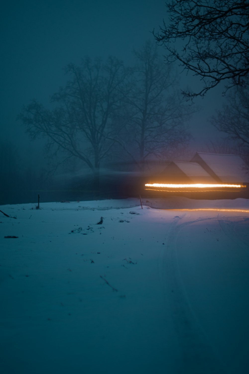 a car driving down a snow covered road at night