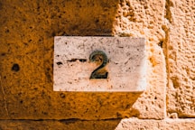 a number two sign on a stone wall