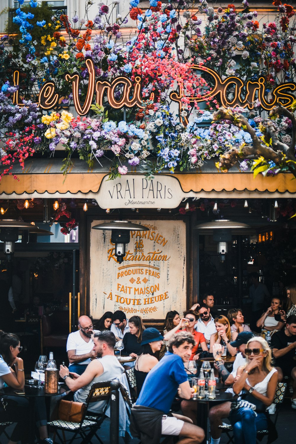 a group of people sitting outside of a restaurant